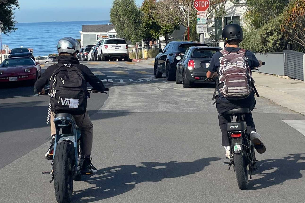 Teen boys with backpacks riding ebikes