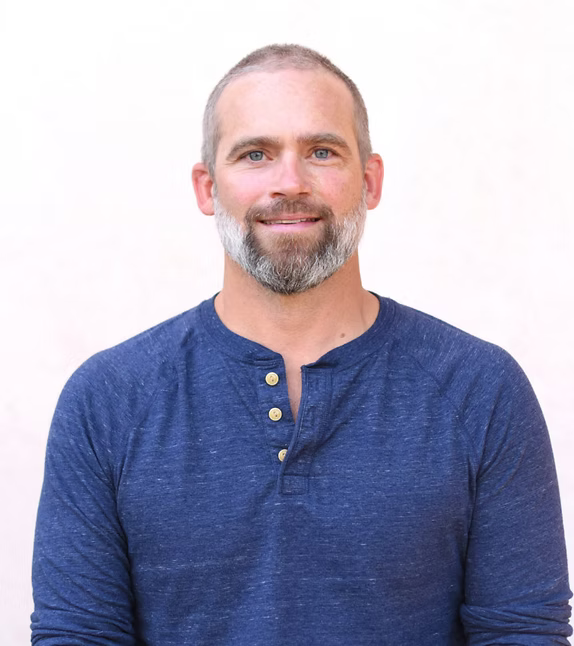 Man wearing a blue long-sleeve shirt with buttons on a white background