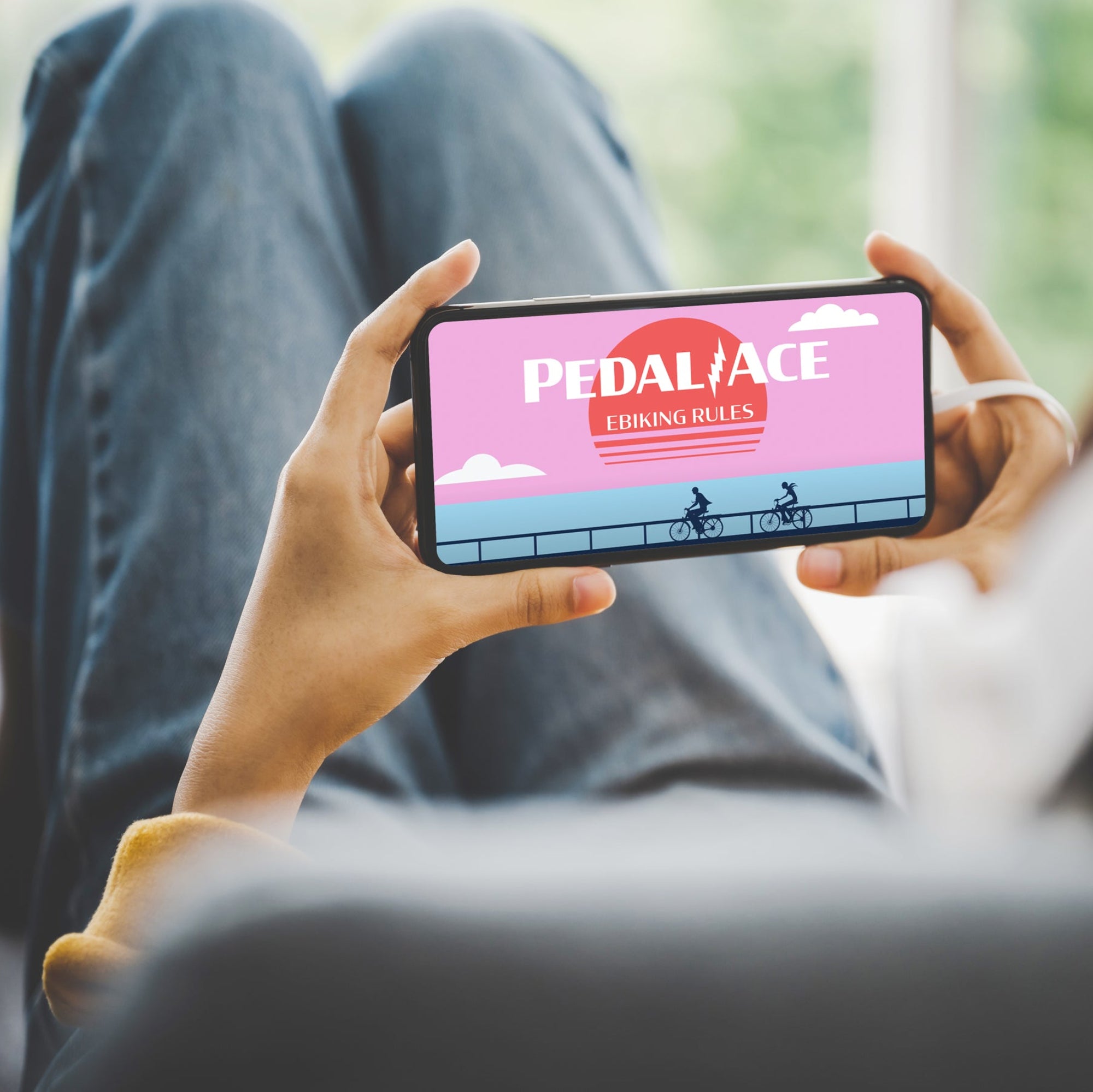 Person holding a smartphone with the PedalAce ebiking rules course displayed